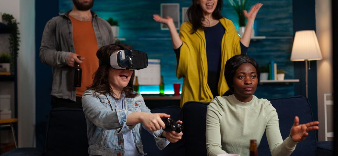 Happy gamer woman with virtual reality headset winning online competition